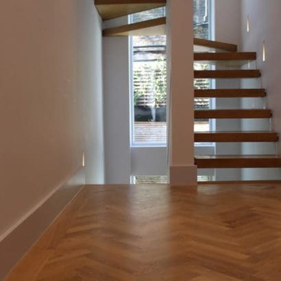 wooden stairway refurbishment completed with white walls and stairwell lighting