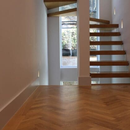 wooden stairway refurbishment completed with white walls and stairwell lighting