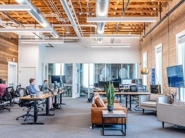 decorators created industrial styled office with exposed ceiling, wood planning and fresh grey carpets