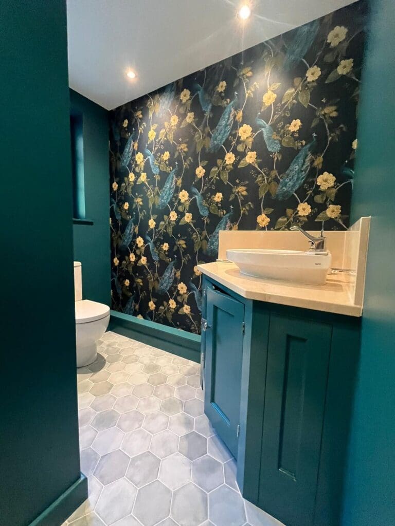 bathroom interior covered with floral wallpaper and dark green theme