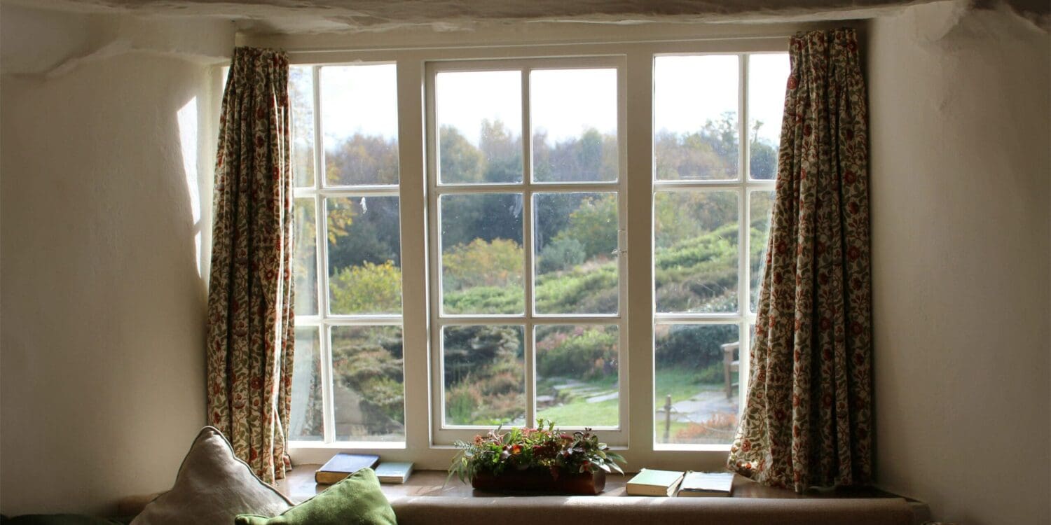 cottage living room window dressed with floral curtains