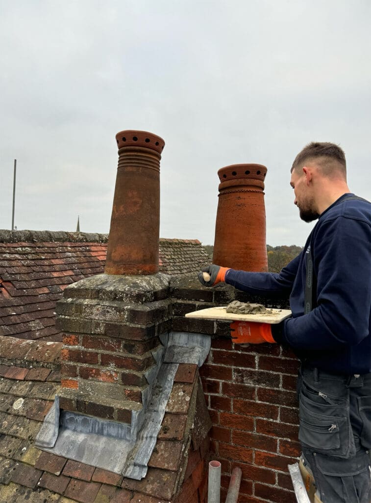 contractor completing chimney repairs as part of exterior house maintenance checks