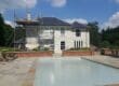 Large house painting exterior brick walls in sage green masonry paint