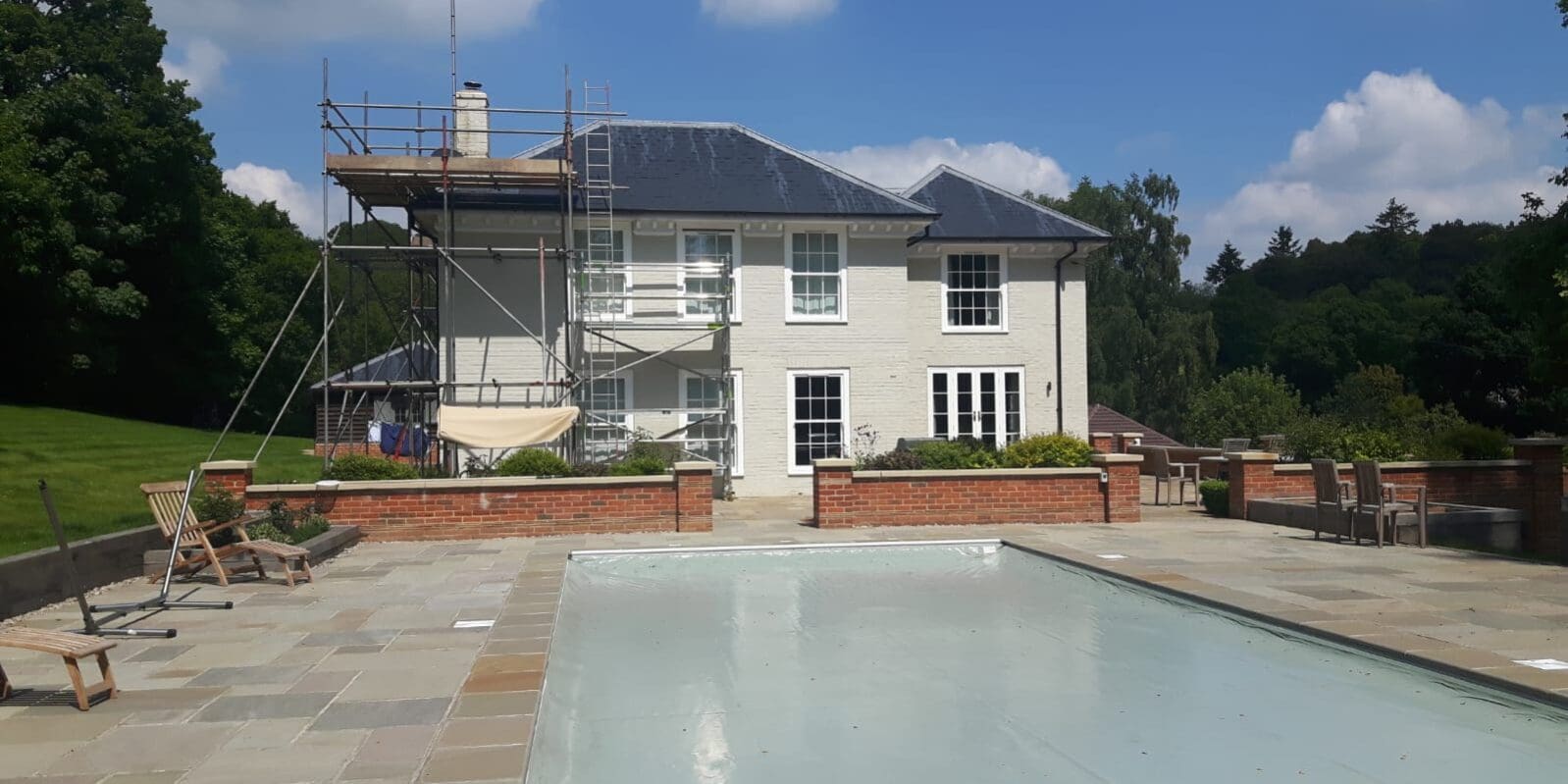 Large house painting exterior brick walls in sage green masonry paint