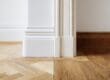 Interior corner with white skirting boards and herribone floors