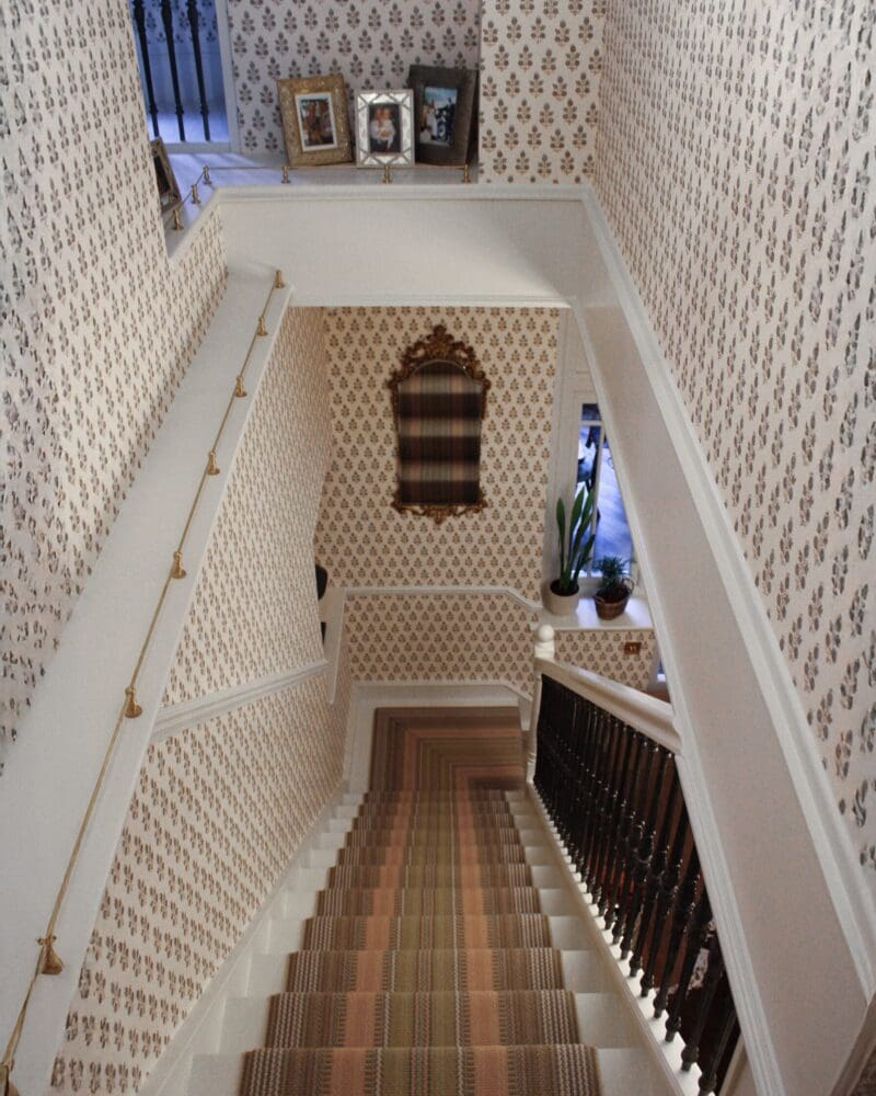 long down at the top of the wallpapered staircase in country home